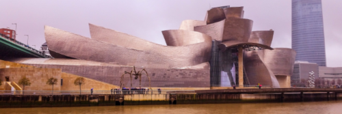Futuristisch gebouw aan rivier met moderne architectuur.