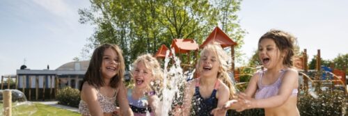 Kinderen spelen met water in de zomer.