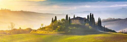 Italiaans platteland bij zonsopgang, met villa en cipressen.