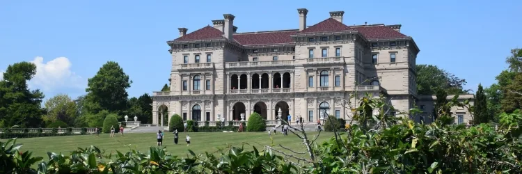 Historisch groot landhuis met groene tuin op zonnige dag.